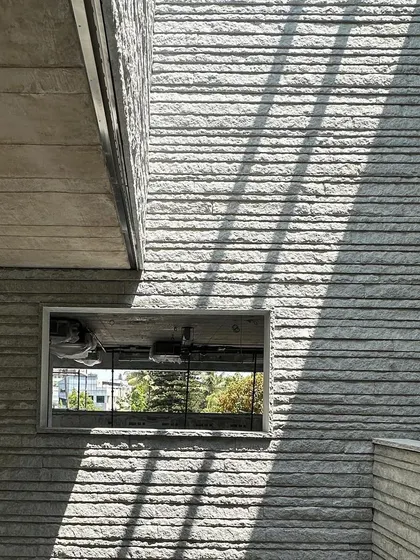 The play of light and shadow on a wall of hand-chiseled stone from a work in progress. For us, the marks of the craftsman's tools and the inherent texture of the material are not imperfections to be hidden, but the very soul of the building.