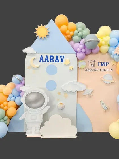 A complete view of Aarav's "First Trip Around the Sun" theme, showcasing the rocket ship backdrop, astronaut cutout, and colorful balloon galaxy.