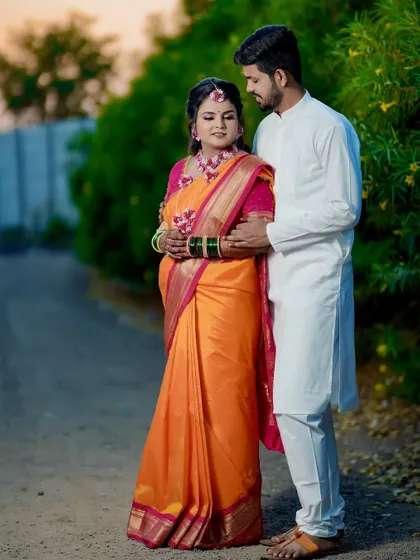 A full-length portrait of the couple in a rustic setting. The groom holds his bride close, creating a simple yet beautiful memory of their Haldi day.