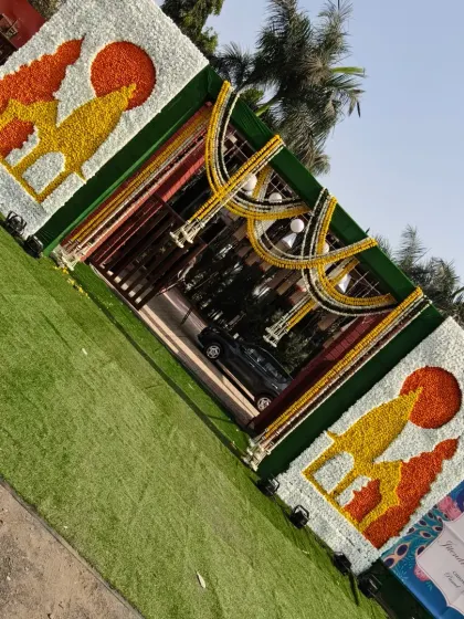 A tilted view of the grand Haldi entrance gate, showcasing the intricate floral work. The camel motifs made from yellow and orange flowers add a unique Rajasthani touch.
