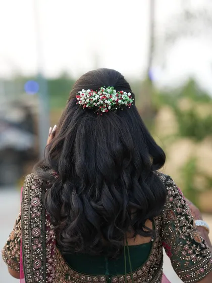 A view of the beautiful floral hair accessory in Dr. Saruna's reception hairstyle. The colourful beads add a unique and festive touch to her look.