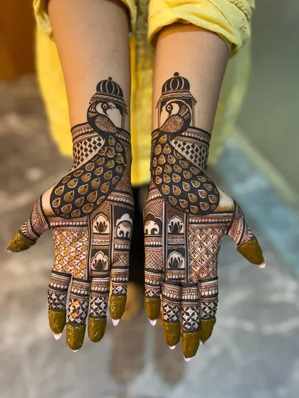 A bold and beautiful design centered around the majestic peacock. The feathers flow down the palm, creating a striking visual, while the forearms feature traditional elephant and architectural elements.