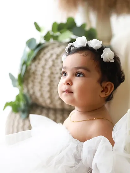 A serene moment from the same session, capturing her gentle smile and the delicate details of her floral headband.