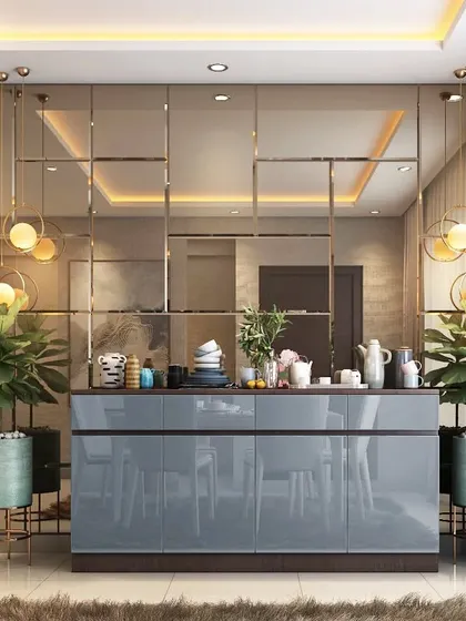 This bar and crockery unit is designed as a stylish partition, featuring a mirrored back wall that enhances the sense of space. The glossy grey counter and overhead pendant lights make it a perfect spot for entertaining.
