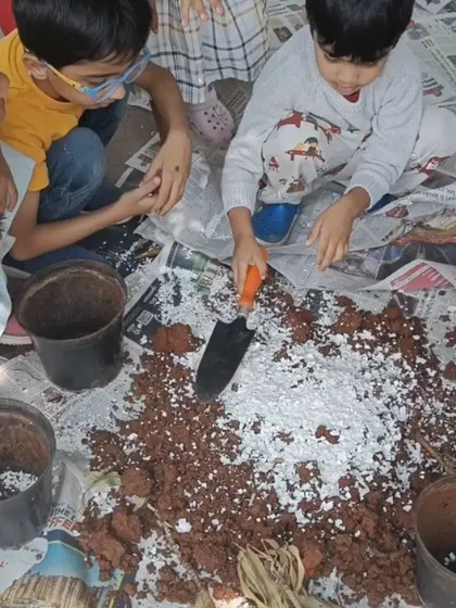 Children work together, using small shovels to mix the crushed eggshells into the soil. This collaborative activity teaches them about teamwork and caring for the earth.