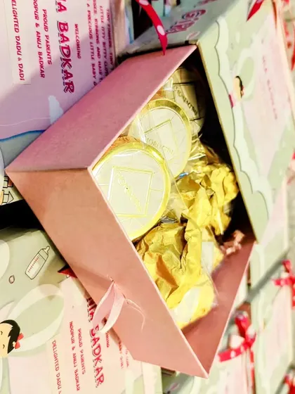 A close-up of my custom baby girl announcement boxes. These were filled with premium chocolates and waffles, with a personalized sleeve celebrating the arrival of baby Nia.