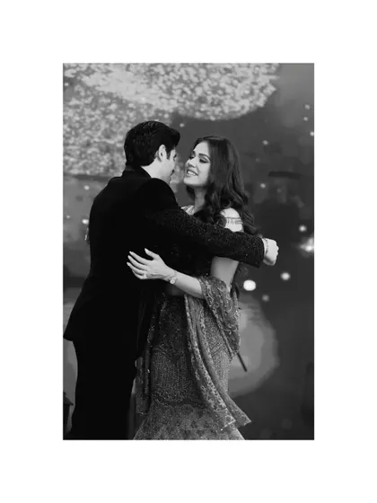 A timeless black and white photo of a couple sharing a slow dance. This image focuses on their gentle embrace and happy expressions, capturing a classic romantic moment.