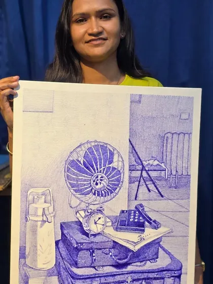 A proud student holds her finished ballpoint pen still life, a testament to the skills learned in our fine arts program.