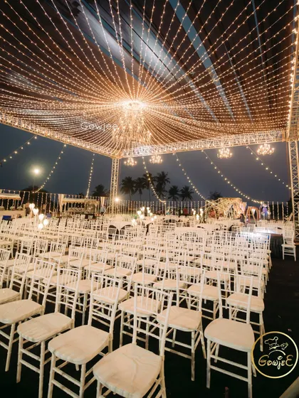 A breathtaking view of an outdoor reception setup under a canopy of fairy lights, creating a magical, starry night effect.
