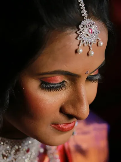 A close-up profile shot of a bride, highlighting her flawless makeup and eyelashes.