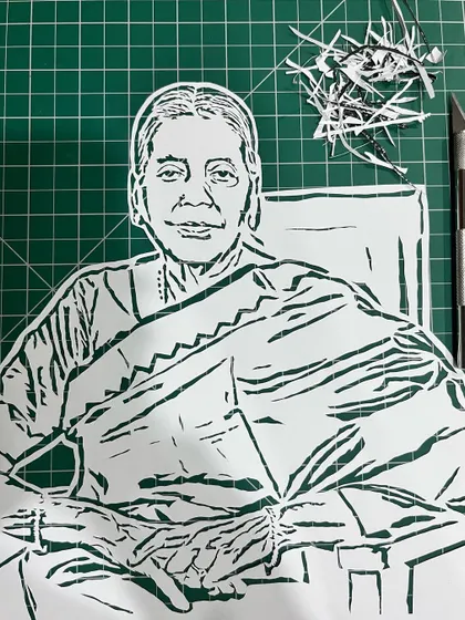 This is a look at a portrait for singer Hariharan's mother, Smt. Alamelu, right after the cutting was done. You can see my craft knife and the tiny paper pieces left behind from the detailed, manual work.