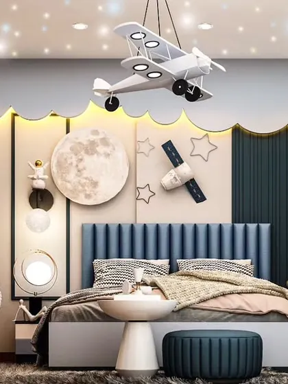 Another view of our popular space-themed kids' room. This angle highlights the custom bed with an astronaut figure, moon and satellite wall decor, and a ceiling light fixture designed to look like an airplane.