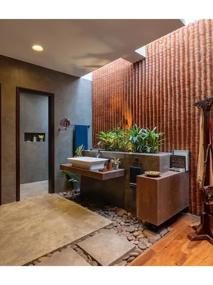This bathroom is designed to feel like a private resort spa, with a skylight, natural materials like stone and wood, and an integrated planter.