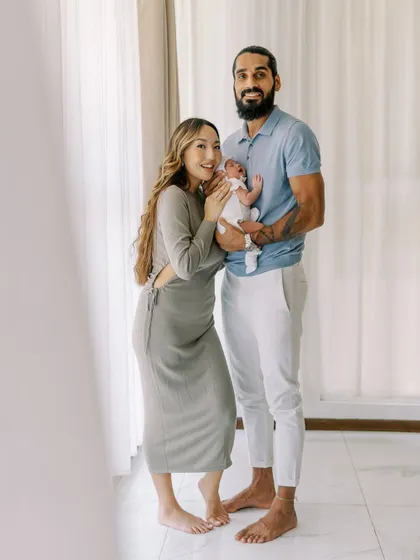 A full family portrait with their newborn. The high-key lighting gives this photo a bright and airy feel.
