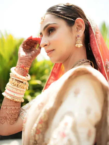 A side-profile portrait of the bride, bathed in natural light, highlighting her elegant features.