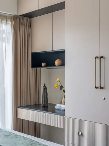 A close-up of the integrated study desk and wardrobe in the 'Flux Abode' master bedroom. The fluted detail and mix of materials show a high level of craftsmanship.