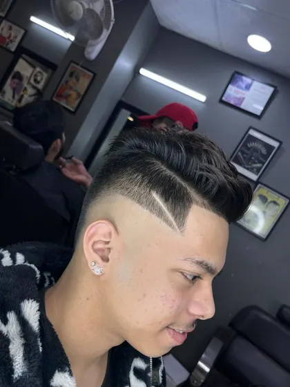 A classic side-part pompadour combined with a modern skin fade. The look is finished with a sharp, clean razor line for extra definition.