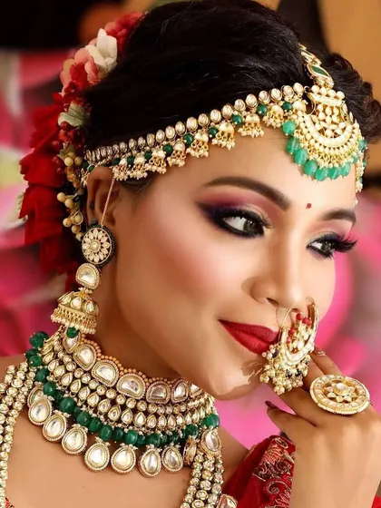 A close-up of a bride admiring her complete look. The rental set includes a choker, a long necklace, and a matching oversized ring.