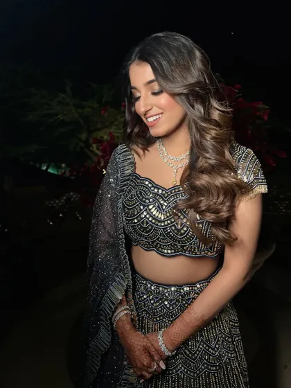 A happy bridesmaid with her hair in soft, open waves, perfect for a Sangeet night.
