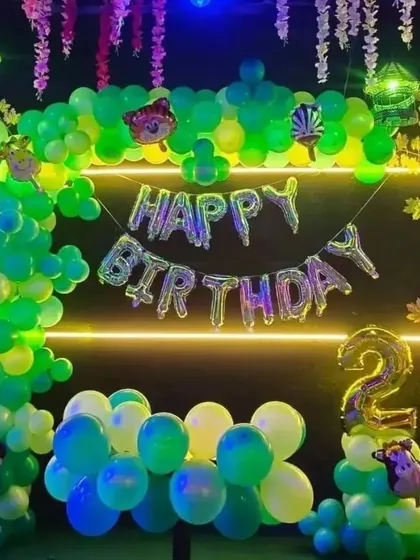 A jungle-themed 2nd birthday with glowing neon lights and hanging vines, creating an exciting nighttime jungle effect.