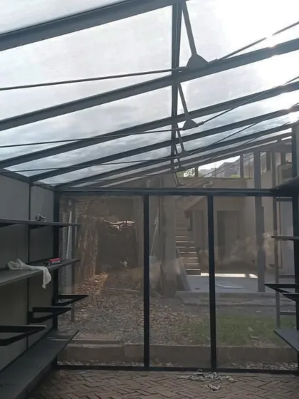 A lightweight metal structure with a translucent roof under construction. This work-in-progress shot shows how we combine different materials, like fabric and checkered panels, to fill interior spaces with a soft, diffused natural light.