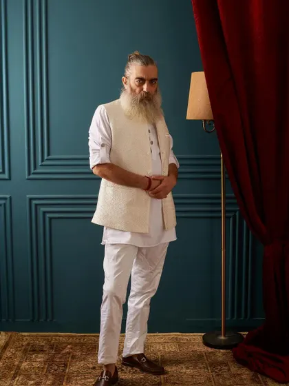 A classic all-white look, elevated by a textured, self-patterned vest. This ensemble is the epitome of classy, comfortable, and timeless festive wear.