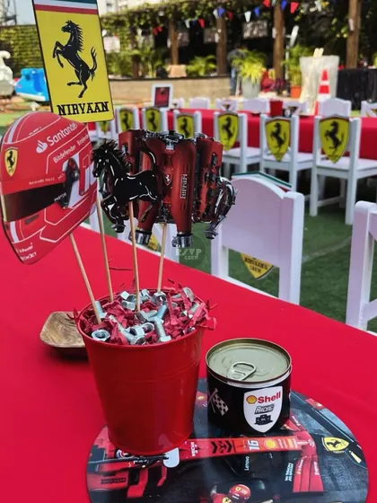Every detail counts. The table centerpieces for this Ferrari party included mini helmets, engine block cutouts, and even a can of 'Shell Racing' oil for that authentic touch.