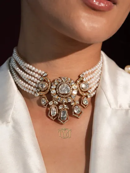 This Diwali, play your cards right. This stunning multi-strand pearl choker, featuring a large Polki and diamond centerpiece, is a winning hand of pure opulence.