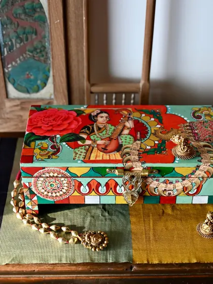 This image shows the box styled with traditional Indian jewelry, emphasizing its purpose as a beautiful storage solution for your own precious items.