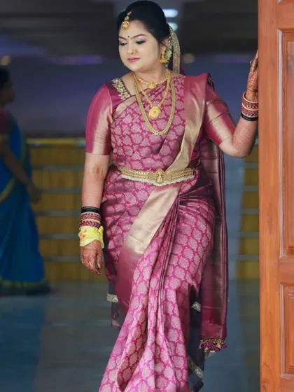 A beautiful bride posing for a photo on her wedding day. Her hair is styled in a traditional updo, a classic and elegant choice for a Muhurtham ceremony.