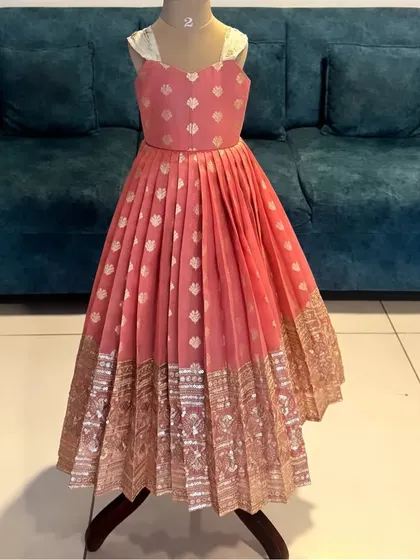 Another angle of the custom peach frock. The high-quality brocade fabric and precise pleating create a beautiful shape and flow, ensuring it looks amazing from every angle.