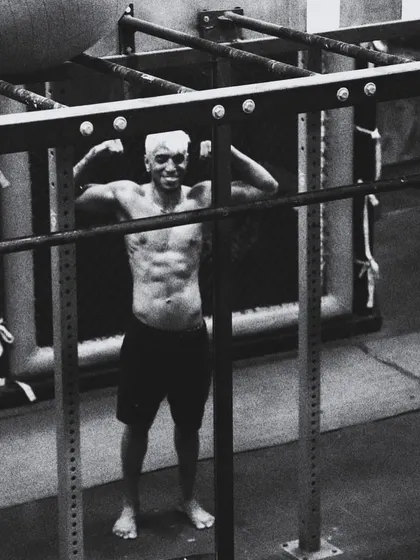 Framed by the rack, a fighter shows the core strength built in our gym. This black and white shot captures the raw, timeless nature of physical training and dedication.