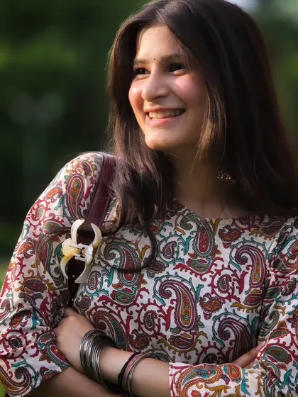 A perfect golden hour portrait. The warm light and her genuine smile create a happy and inviting mood, showcasing a natural and candid moment.
