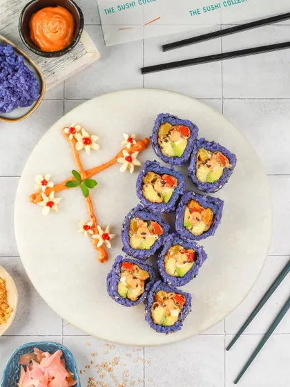 An artistic plating of purple rice sushi, with a delicate flower pattern made from sauce, showcasing culinary creativity.