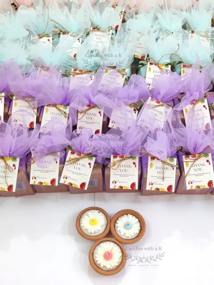 A large order of 120 daisy clay pot candles, packaged in purple and blue net, ready for a first birthday celebration in Bangalore.