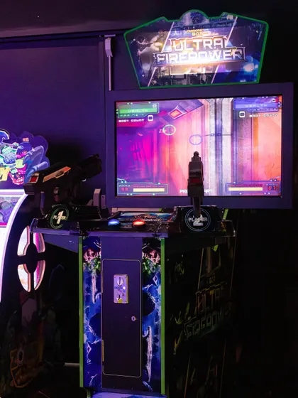 Our arcade section is lit with neon lights, creating an exciting atmosphere for gamers.