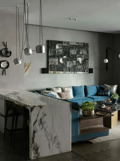 A view of the family lounge showcasing the marble-topped breakfast bar and a striking art piece by Kaushik Saha. The space is a perfect example of how we layer textures, colors, and art to create a cohesive design.