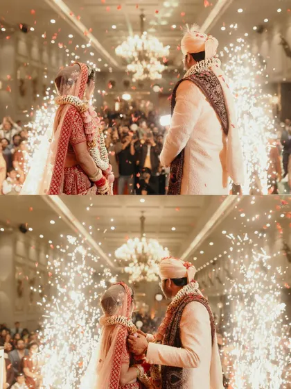 The Varmala exchange in a beautifully lit grand hall, with cold pyro adding a touch of magic to this central wedding ritual.
