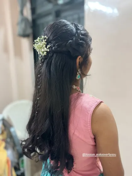 This half-up, half-down hairstyle features intricate braids and a delicate trail of pearls. It’s a beautiful way to add detail to your look while keeping your hair down.