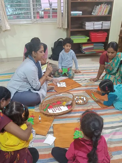 A storyteller guides a young boy during a Christmas themed craft activity. We provide individual attention to help each child bring their creative vision to life.