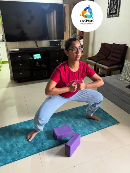 A client practices Goddess Pose (Utkata Konasana), a powerful squat variation that strengthens the entire lower body, including glutes, hips, and thighs, while also opening the hips.