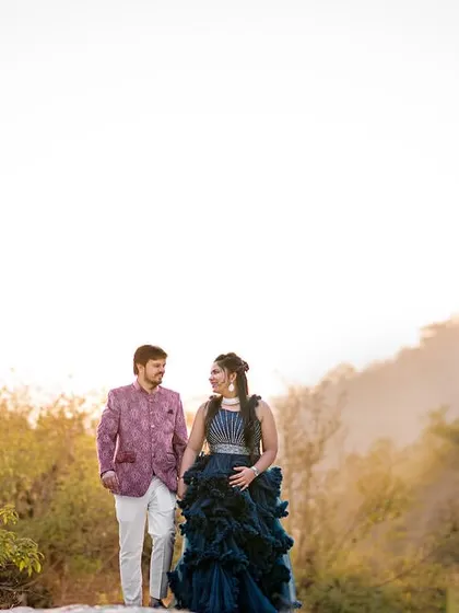 A walk through a misty, golden landscape by the river. The unique colors of their outfits and the soft light create a dreamy, almost painterly pre-wedding photograph.