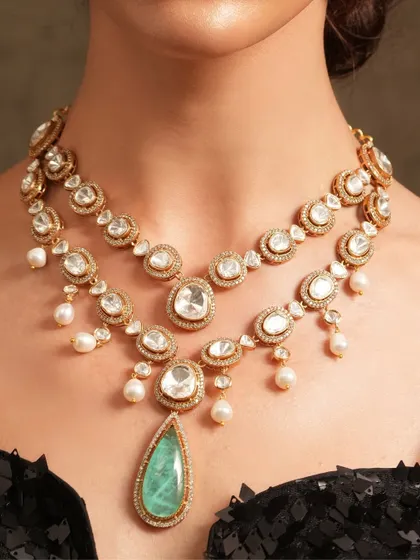A layered polki necklace with a large emerald drop, a perfect piece for a destination wedding that requires a touch of indie soul and luxe sparkle.