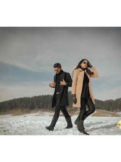 A cool, back-to-back pose against the vast snowy landscape of Kashmir. This shot has a modern and stylish feel.