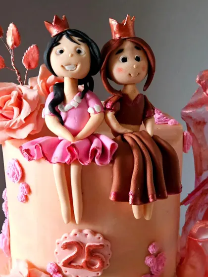 A close-up of the handcrafted princess figurines from the mother-daughter birthday cake. Each one is dressed in a unique, detailed gown.