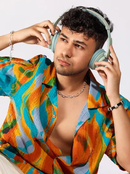 A vibrant, tropical-themed shoot for a men's summer collection. I paired a colorful printed shirt with white shorts and casual accessories like headphones and a speaker to create a fun, youthful, and energetic vibe.