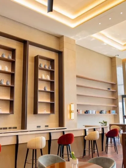 The bar at the Elevate Clubhouse is a central feature of the main social hall. With its clean lines, comfortable seating, and extensive shelving for display, it serves as a stylish and functional hub for the community.
