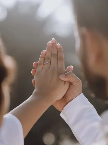 A close-up on the bride's hand, showcasing her engagement ring as the groom holds it gently. A beautiful shot symbolizing their commitment.