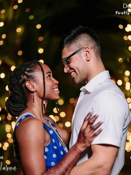 A quiet moment together amidst the celebration. The couple shares a smile against a backdrop of firefly lights, a simple yet magical setting that highlights their love.