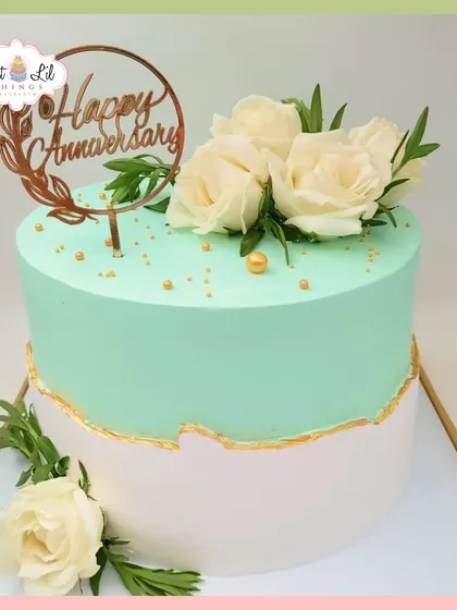 A fresh and elegant anniversary cake. This mint green and white cake is decorated with a simple gold fault line and fresh white roses.
